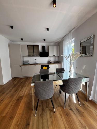 a kitchen and dining room with a glass table and chairs at Apartament ul Jodłowa Malinka in Opole