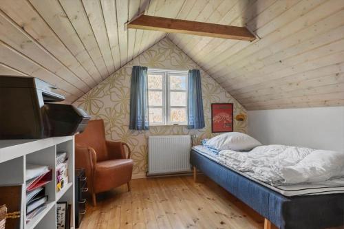 a bedroom with a bed and a window in a attic at R530-Store-Heddinge-Straedet-10 in Holtug