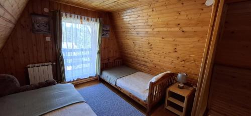 a small room with a bed and a window at Vikendica Luna in Gornja Šišava