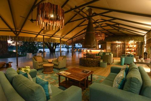 a large living room with blue couches and a table at Chundu Island in Victoria Falls