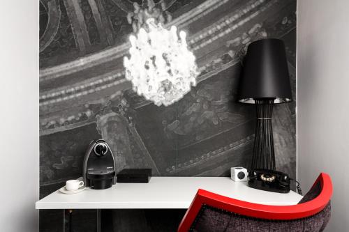 a desk with a red chair and a chandelier at ibis Styles London Southwark - near Borough Market in London