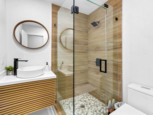 a bathroom with a shower with a sink and a mirror at Casa Playa Coastal Comfort 10 Min From Beach in Hallandale Beach