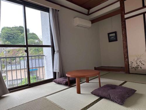 a room with a table and a large window at 勝浦の家 in Katsuura