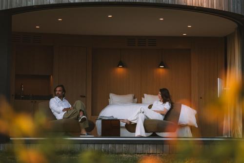 a man and woman sitting in chairs in a hotel room at Haras de Castellane in Pertuis