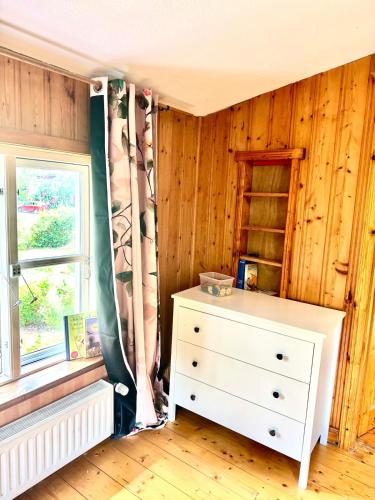 a bedroom with a white dresser and a window at House at Jenischpark in Hamburg