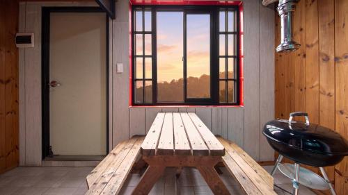 a wooden bench in a room with a window at gapyeong newcastle pension in Gapyeong