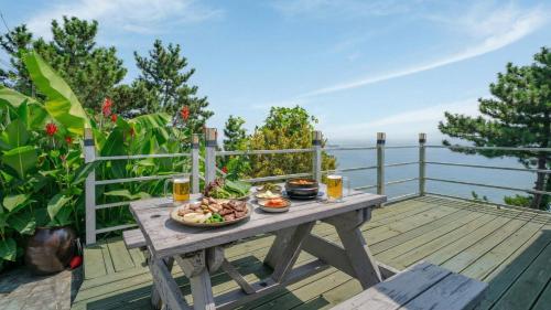 a picnic table with a plate of food on a deck at Namhae baramundeok Pension in Namhae