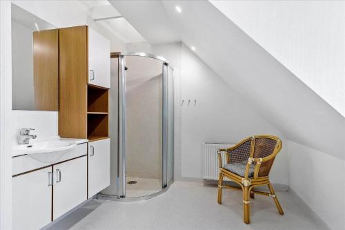 a bathroom with a shower and a chair next to a sink at 0045-Romo-Thadesvej-13 in Høm