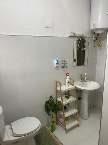 a white bathroom with a toilet and a sink at LANISCA'S Home in Yaoundé