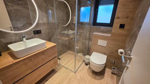 a bathroom with a sink and a toilet and a shower at Villa Jelena Rooms and Apartments in Kovačić