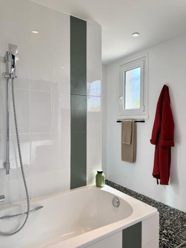 a white bathroom with a tub and a window at B&B Le Chardon in Saint-Gervais-les-Trois-Clochers