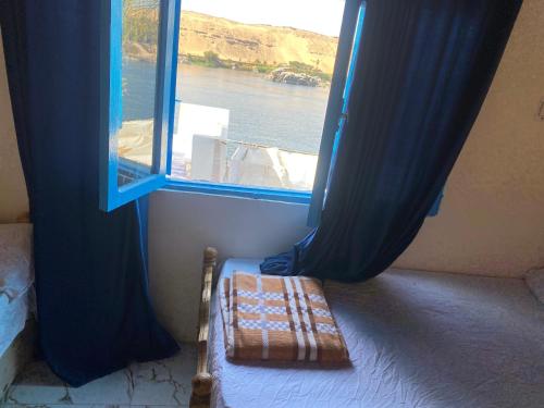 a room with a window and a bed with a blanket at Hooly Nubian in Aswan