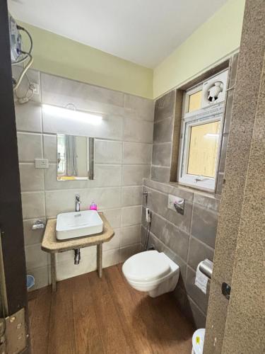 a bathroom with a toilet and a sink at Nestoria Corporate Services in Pune
