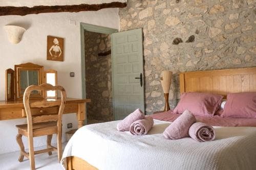 a bedroom with a bed with pink pillows on it at Casa de la Suerte in Benissa