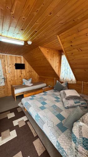 a bedroom with two beds in a wooden cabin at Cabana Dara in Cumpăna