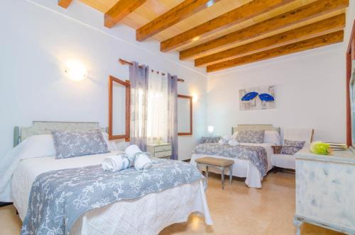 a bedroom with two beds and a living room at Can Pedro Ros in S'Illot