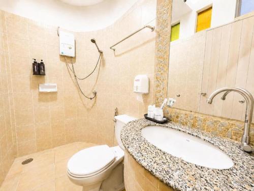 a bathroom with a toilet and a sink at Chalet De Palm Resort Hatyai in Hat Yai