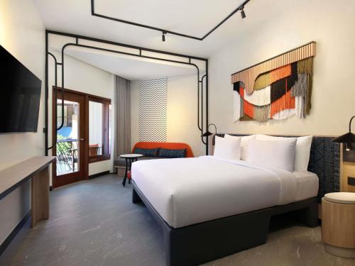 a hotel room with a bed and a television at Tribe Bali Legian in Legian