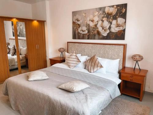 a bedroom with a large bed with pillows on it at Tcc - Skysuites in Accra