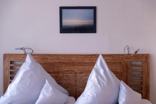 a picture hanging above a bed with white pillows at Hotel Zur Post in Roßbach