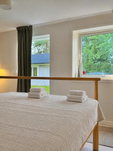 a bedroom with a bed with towels on it at Modern Seaside Guesthouse with Archipelago Views in Nacka