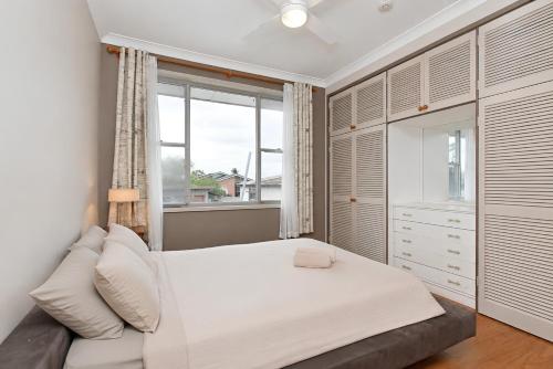 a bedroom with a white bed and a window at Coal d' Vine VIEW - Cessnock NSW in Cessnock
