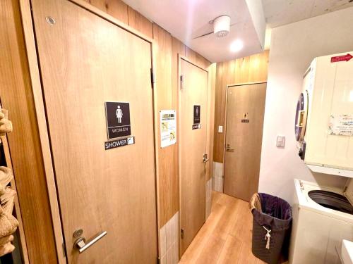 a hallway with a door with a sign on it at Rhodes Kagurazaka in Tokyo