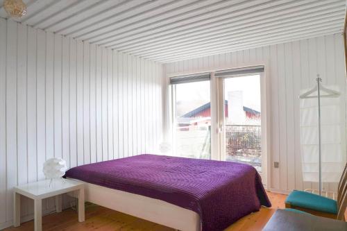 a bedroom with a purple bed and a window at 14234-Grevinge-Strandmosen-11 in Grevinge