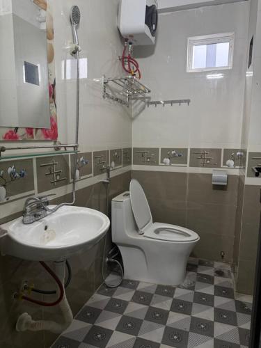 a bathroom with a white toilet and a sink at She Stay in Hòa Bình