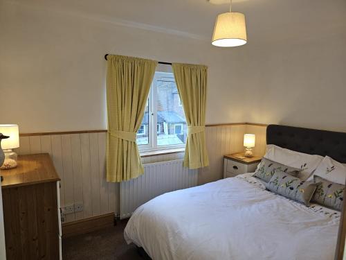 a bedroom with a white bed and a window at Twisted Chimney View in Alford