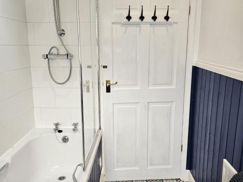 a white bathroom with a tub and a shower at Twisted Chimney View in Alford