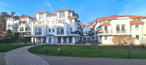 a large white house with a lawn in front of it at Sonnensegler - Bade- & Saunawelt täglich inklusive in Baabe