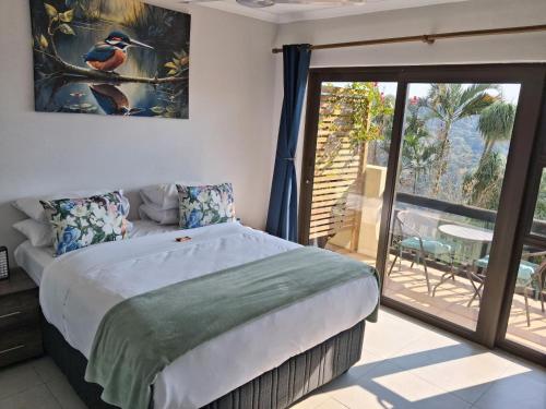 a bedroom with a large bed and a balcony at Serenity Place B&B and Conference, wedding venue in Durban