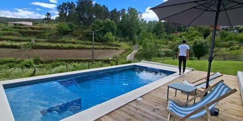 a man standing on a deck next to a swimming pool at Quinta da Peça Douro Wine Region Retreat, Private Pool Villa in Vila Real