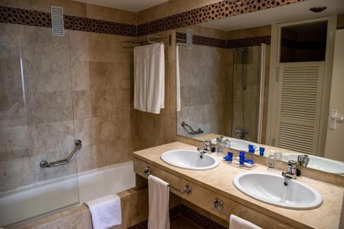 a bathroom with two sinks and a tub at AR Almerimar in Almerimar