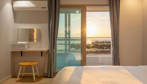 a bedroom with a bed and a view of the ocean at Sokcho pensionbyeol in Sokcho