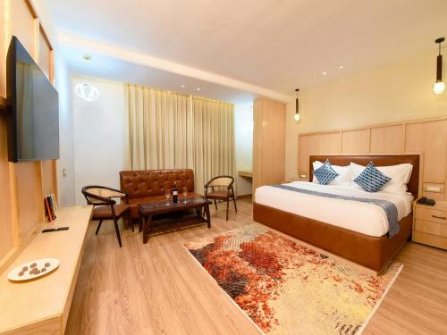 a hotel room with a bed and a couch and a table at Palette Hotel by CheckIn Amritsar, Airport Road in Amritsar