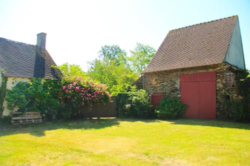 a house with two red doors and a yard at Gite cosy 4 pers en vallée de la Creuse in Baraize