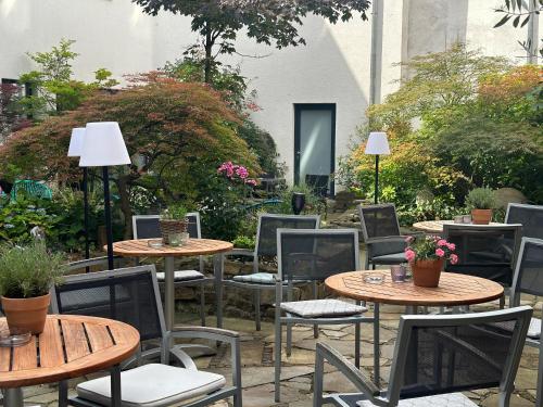 a group of tables and chairs in a garden at Hotel Esplanade Dortmund in Dortmund