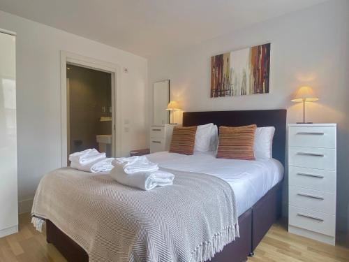 a bedroom with a large bed with towels on it at Your Space Apartments - Eden House in Cambridge