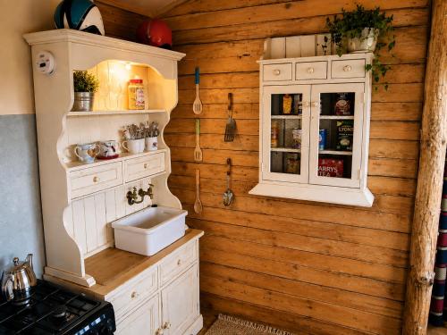 a kitchen with white cabinets and a sink at Donegal Oceanview Retreat in Drumaville