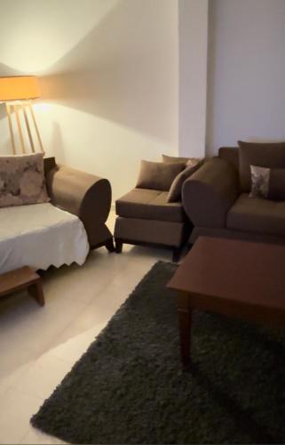 a living room with a couch and a couch and a bed at شمس in Hammamet Nord
