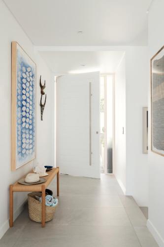 a white hallway with a table and a door at The Lighthouse in Simonʼs Town