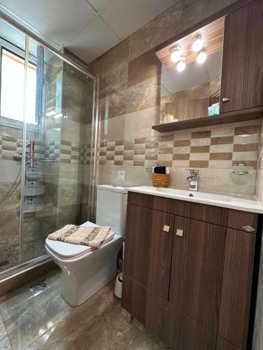 a bathroom with a toilet and a sink and a shower at Breeze Apartments Megara - Nest in Megara