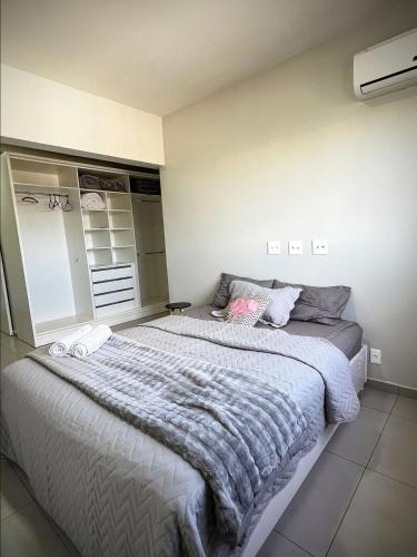 a bedroom with a large bed with a gray blanket at Edifício Madrid | Ayrton Senna in Toledo