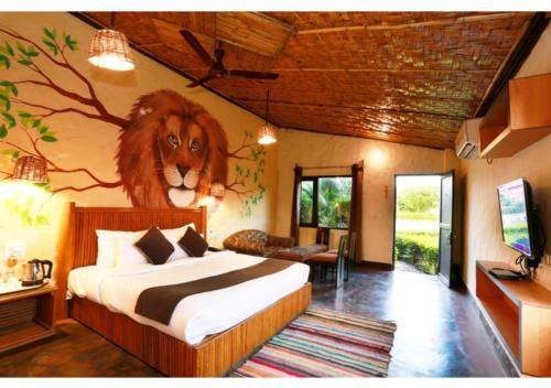 a bedroom with a lion painting on the wall at Corbett Soho Resort in Haldwāni