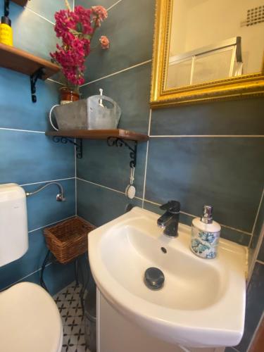 a bathroom with a sink and a toilet and a mirror at Villa Lavanda Vendégház & Spa in Gyulakeszi