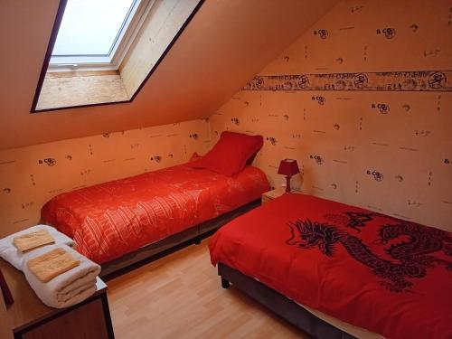 a attic room with two beds and a window at La Vie en Rose et Azur in Cluses