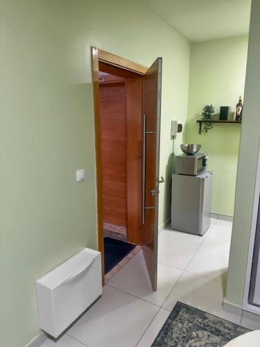 a kitchen with a wooden door in a room at AP2B Praia in Praia
