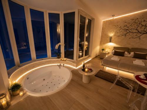 a bathroom with a large tub in a room with a bed at OLYMPUS PARK amnesia in Mesagne